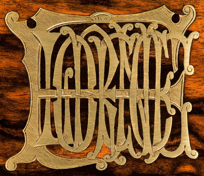A brass inlaid monogram forming the name 'Florence', from an antique jewellery box in coromandel with Betjemann Patent mechanism.