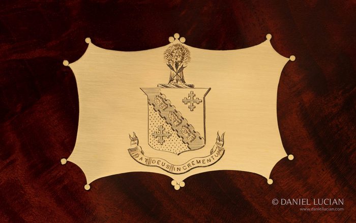 Engraved coat of arms from an antique jewellery box in flame mahogany.