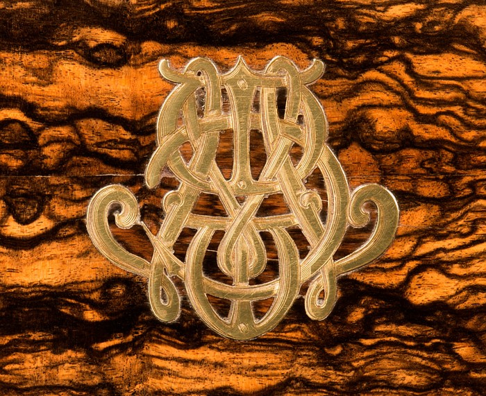 A brass inlaid monogram from an antique jewellery box by Charles F. Hancock.