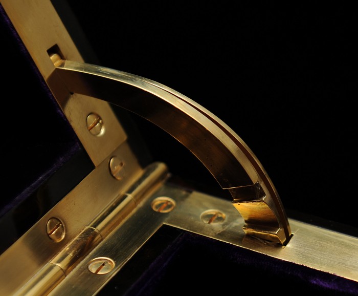 Antique brass quadrant hinge with incremental ridges for mirror angle adjustment.