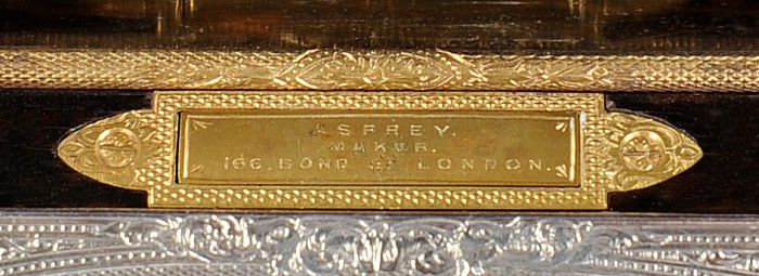 Engine turning on an Asprey manufacturer's plate and hinge from an antique dressing case.