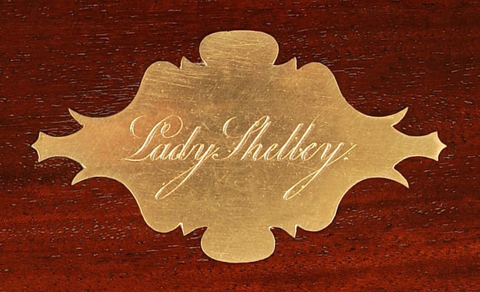 Brass escutcheon bearing the engraved name 'Lady Shelley' from a mahogany antique jewellery box.