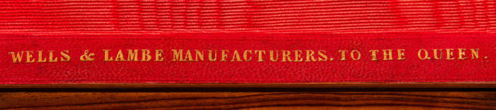 'Wells & Lambe Manufacturers To The Queen' gold tooled manufacturer’s mark onto leather.